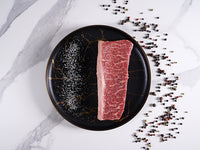 australian wagyu pichna center slice ms9 9oz with salt and peppercorns on marble background - Halal Wagyu